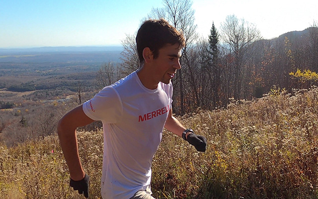 Rémi Leroux running somewhere in mountains in Merrell T-shirt.