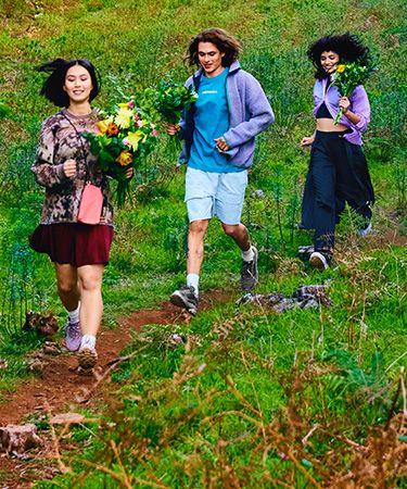 A group of people walking on a path with flowers.