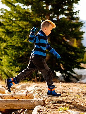 Kid runs in winter boots.