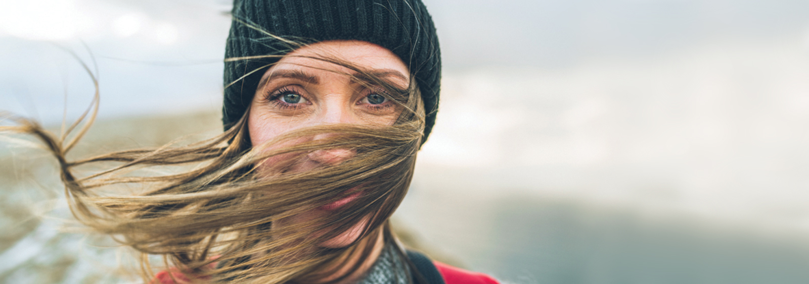 Rannvá Joensen with her hair blown in front of her face with the Faroe Islands in the background.