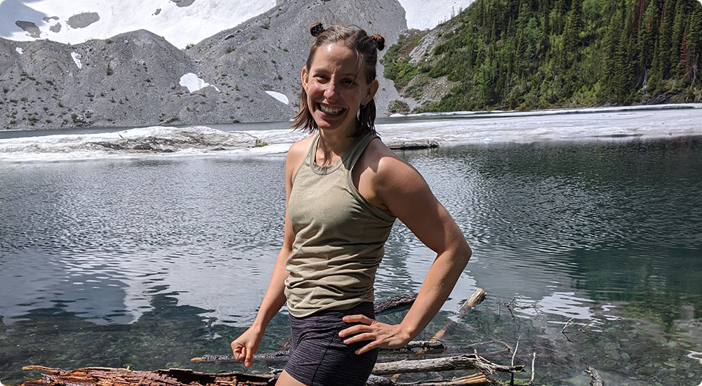 Cassie standing in front of an alpine lake.