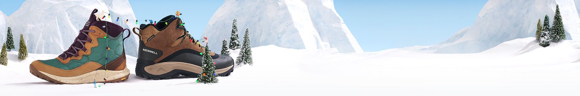 Une paire de chaussures dans la neige avec une montagne enneigée couverte d'arbres en arrière-plan.