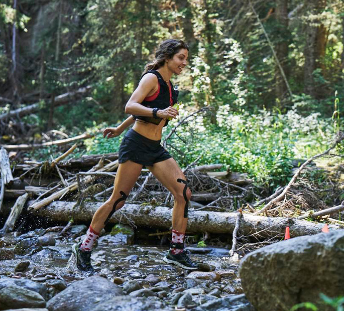 Emilie Mann running somewhere in the wood in Merrell shoes.