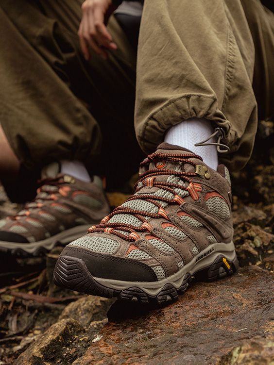 A close-up of a person's feet wearing Merrell Moab Boots.