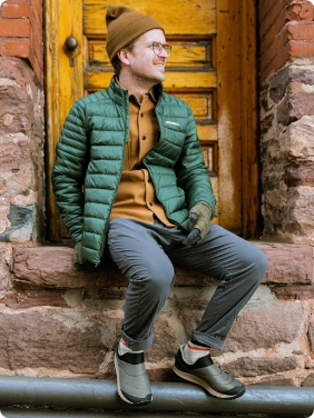 Man sitting with winter apparel.