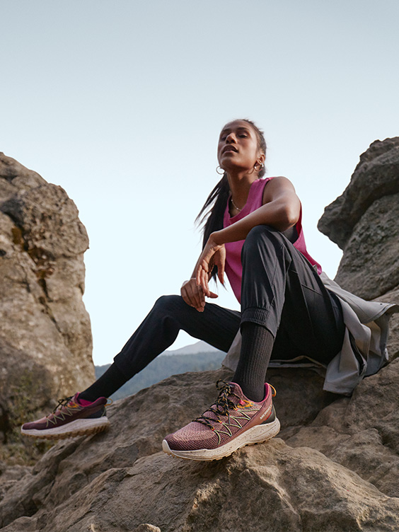 Someone sitting on the rock wearing Merrell shoes.