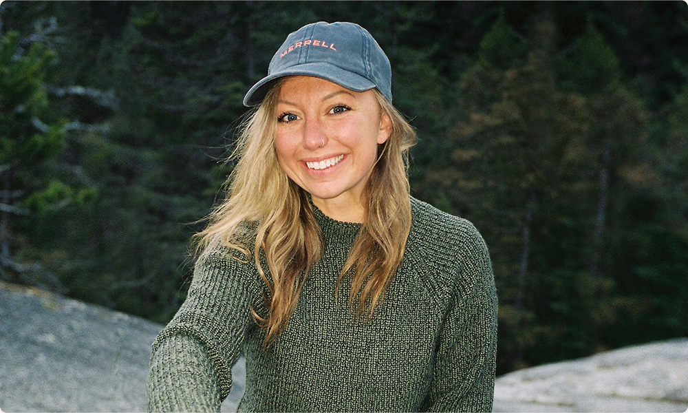 Christie standing in front of an alpine lake.