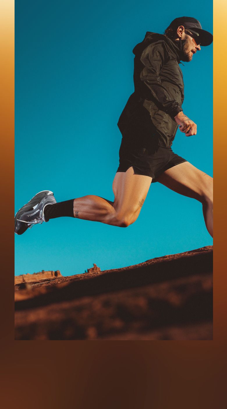 Person running outdoors through red rock canyons wearing Merrell shoes
