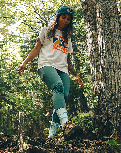 Johany Sergerie standing on a log in the woods.