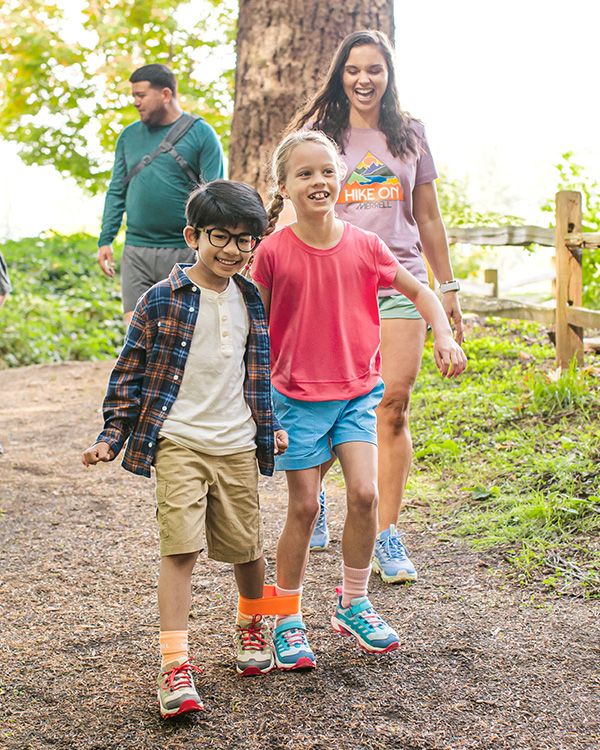 A group of people walking on a path wearing Merrell shoes.