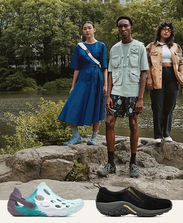 A group of people standing on rocks by water.