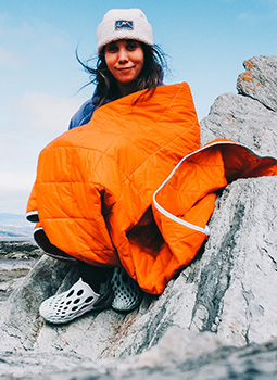 Johany Sergerie assis sur un rocher portant des chaussures Merrell Hydro Moc.