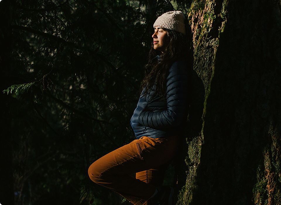 Asalah Youssef leaning against a tree.