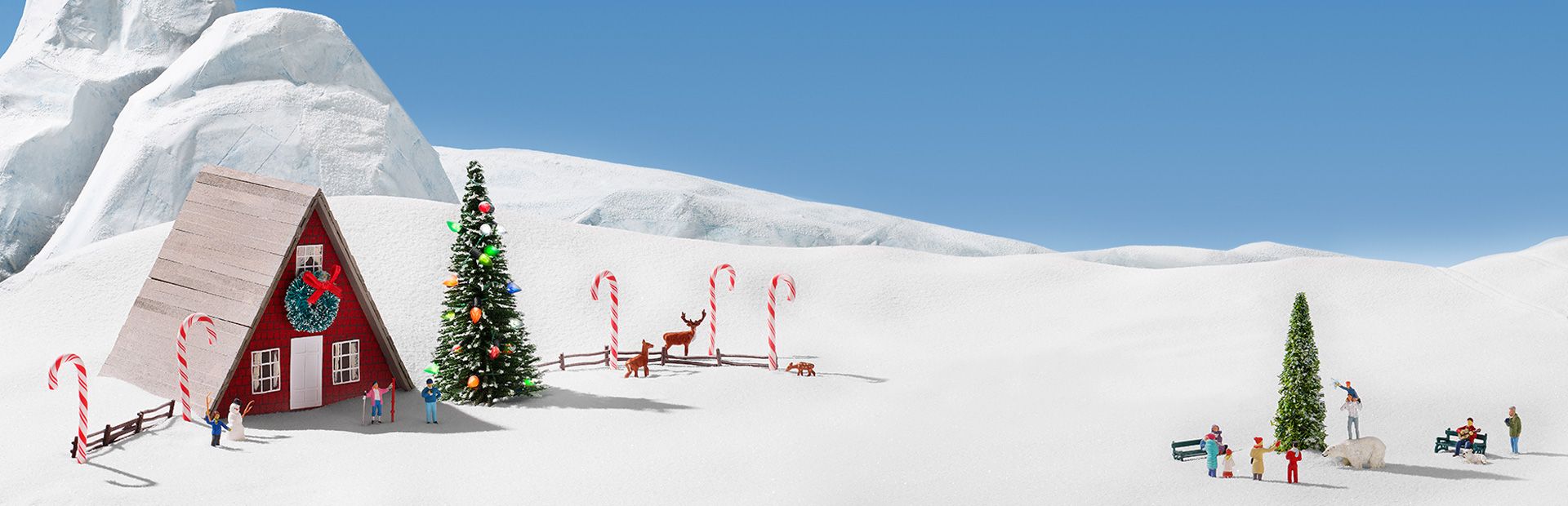 A group of candy canes, people and reindeer in the snow.