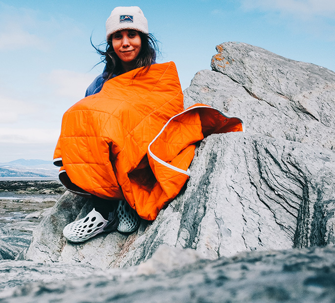 Johany Sergerie assis sur un rocher portant des chaussures Merrell Hydro Moc.