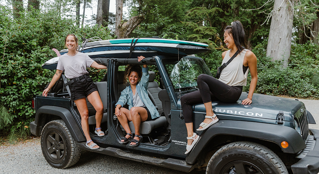 Three people sitting in the car in Merrell sandals.