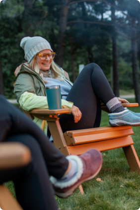 Woman relaxing in an adirondak chair with Merrell clogs