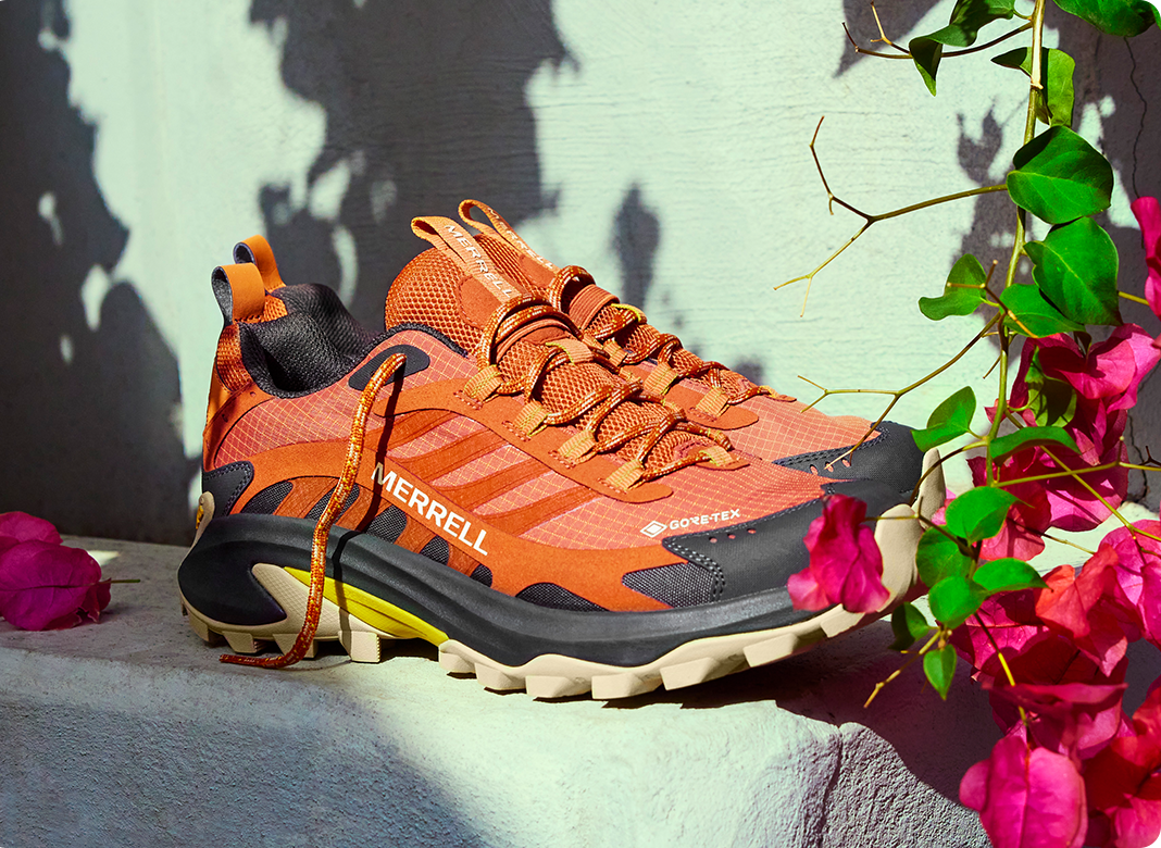 A pair of orange Merrell shoes.