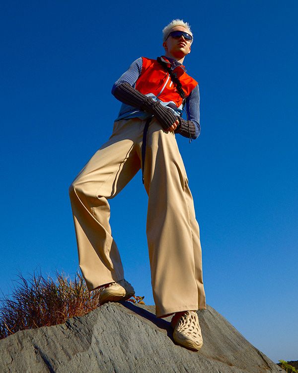 A person standing on a rock wearing Merrell Hydro Next Gen Moc 1 TRL shoes.