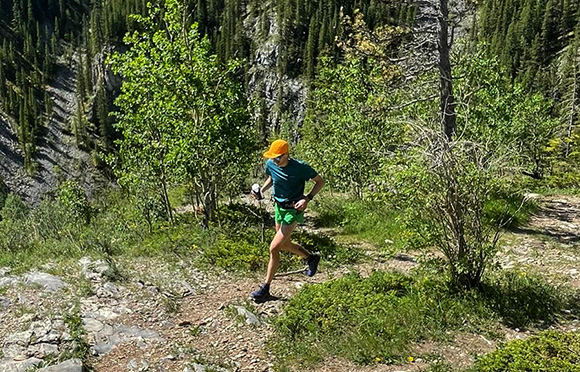 Brandon Miller running on a trail in Merrell gear.