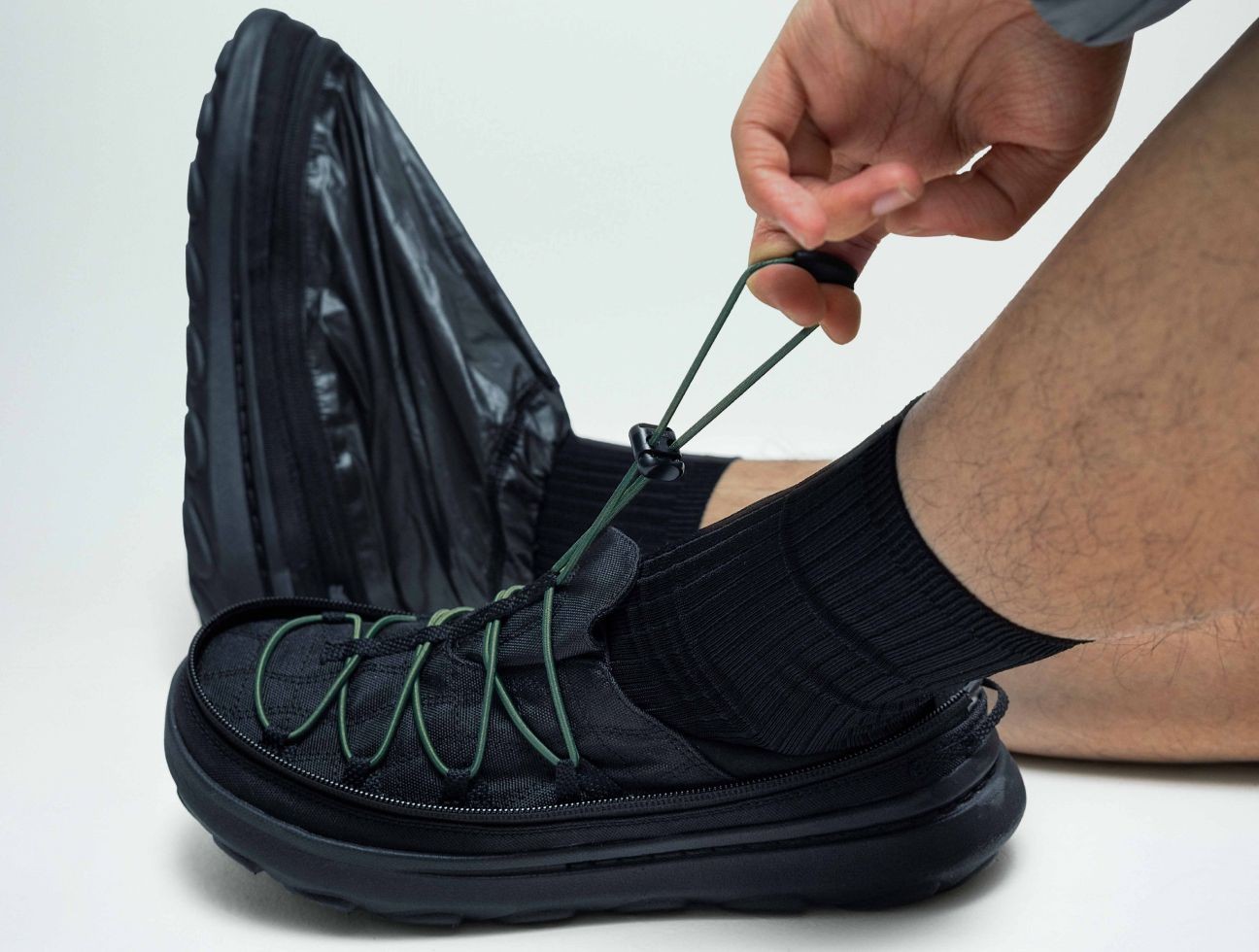 Person putting on the shoe.