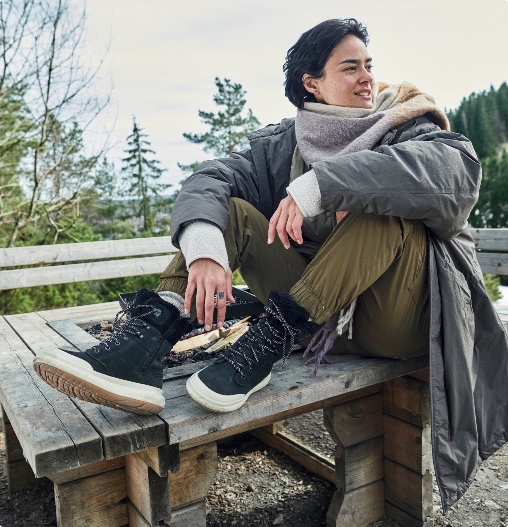 Una persona con botas Merrell que salta de una gran roca.