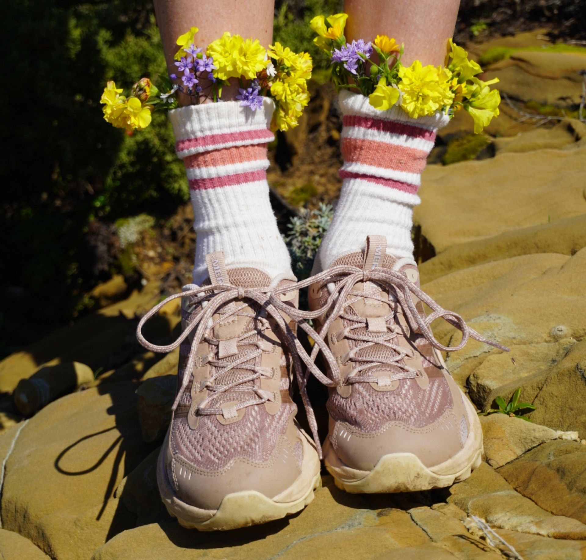 Hiking boots with flowers tucked in socks