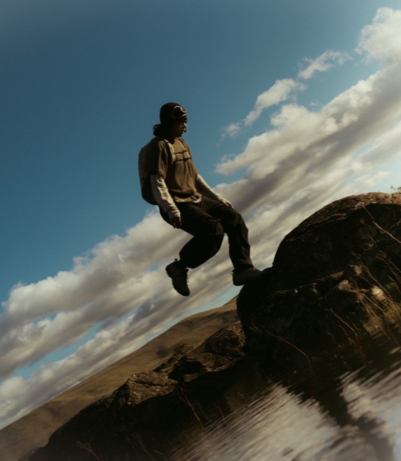 Hiker leaping between rocks on a mountain trail