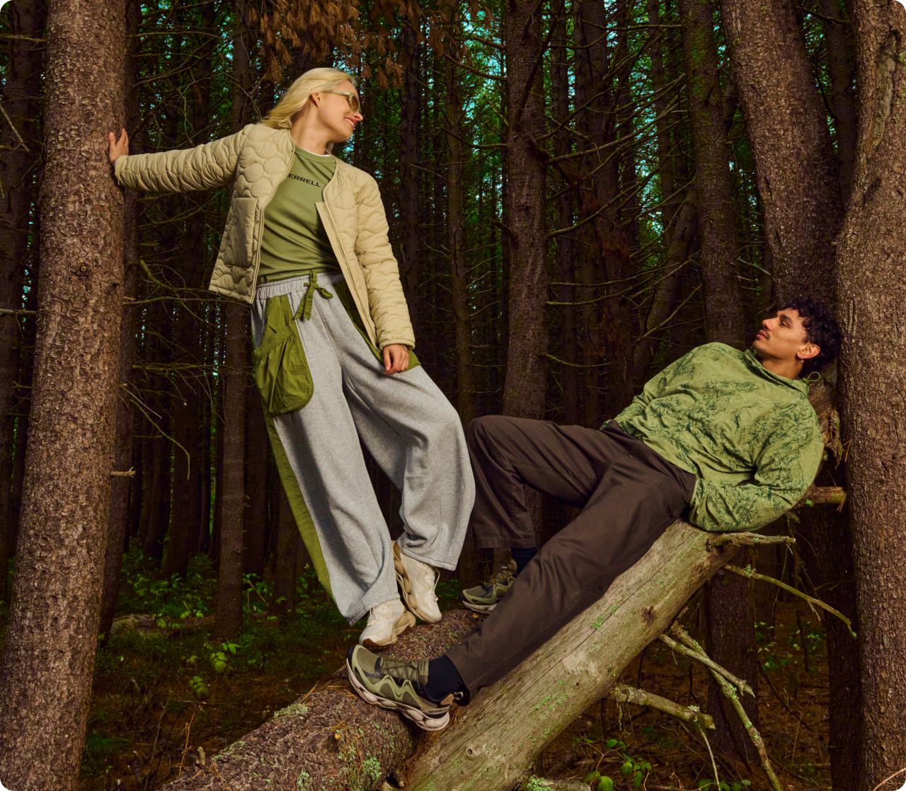 2 people relaxing the woods wearing Merrell gear