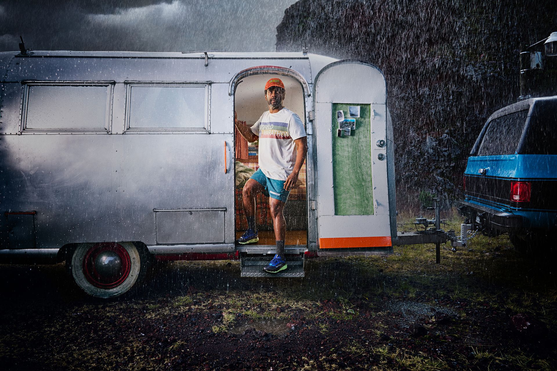 Person, die aus einem orangefarbenen Zelt in einer Outdoor-Camping-Umgebung mit Merrell-Ausrüstung herauskommt