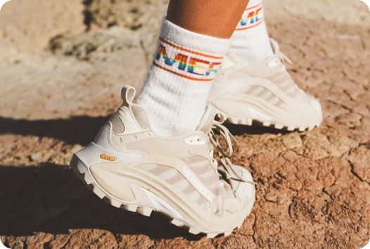 a person's feet in white socks and sneakers