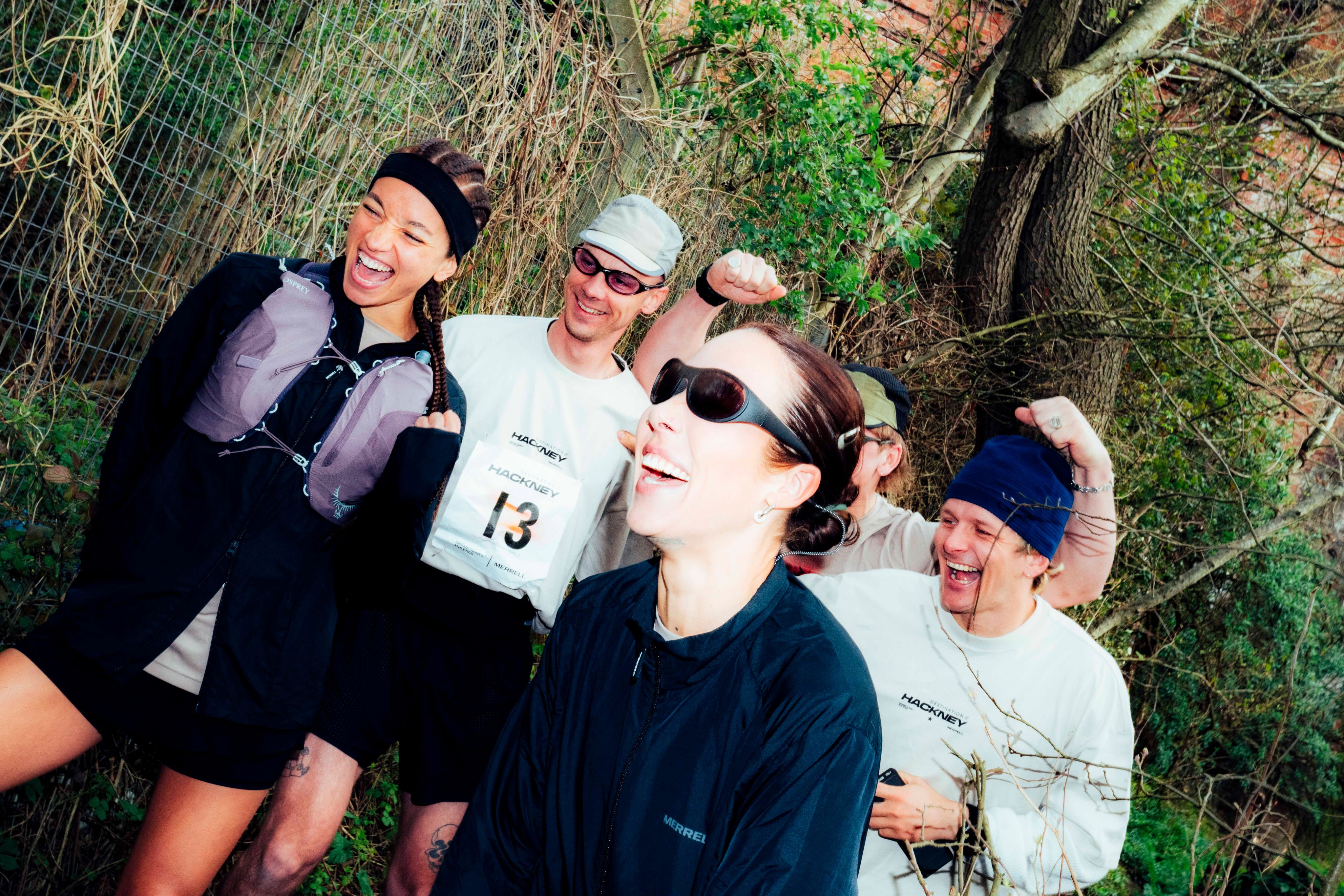 A group of people at a race holding up a Merrell banner