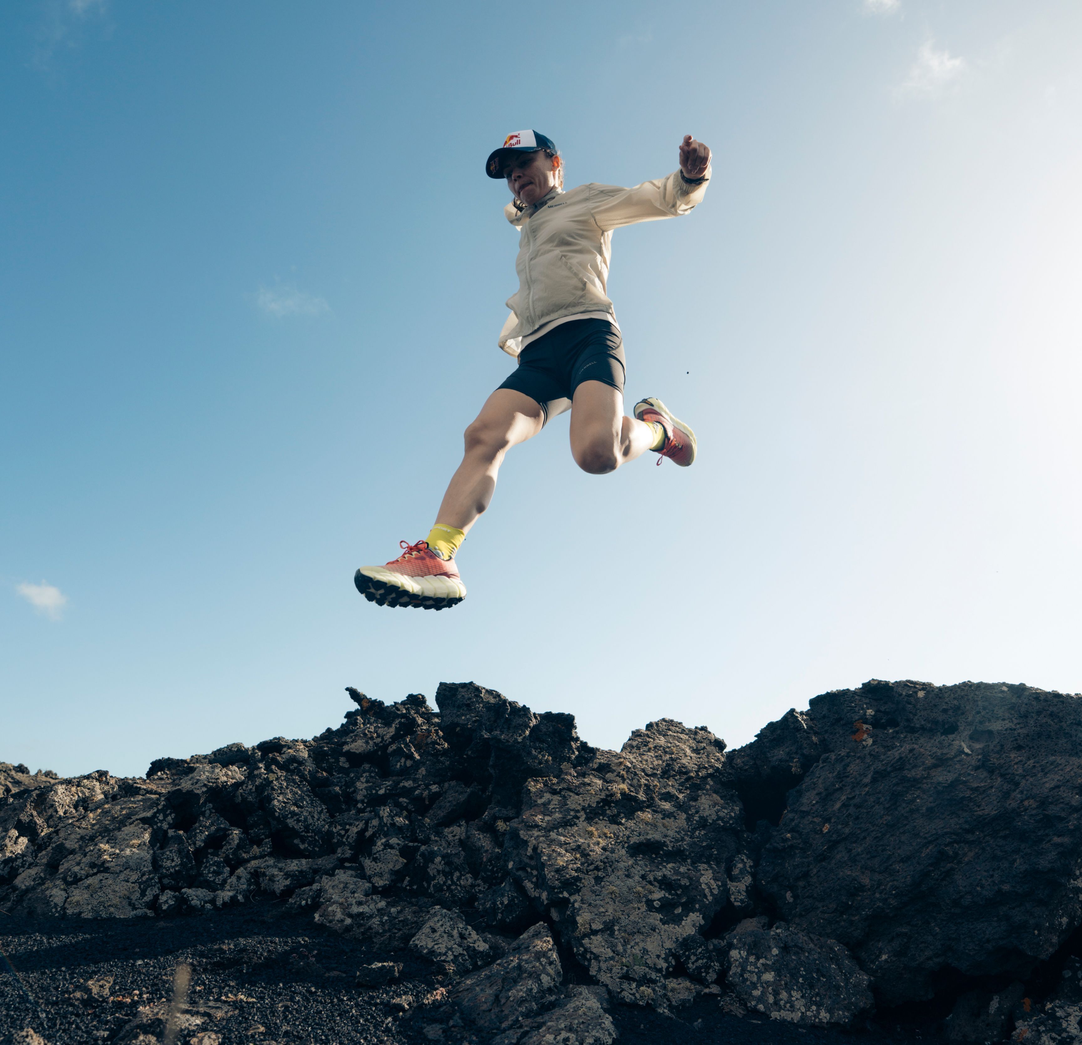 person jumping in the air over rocks