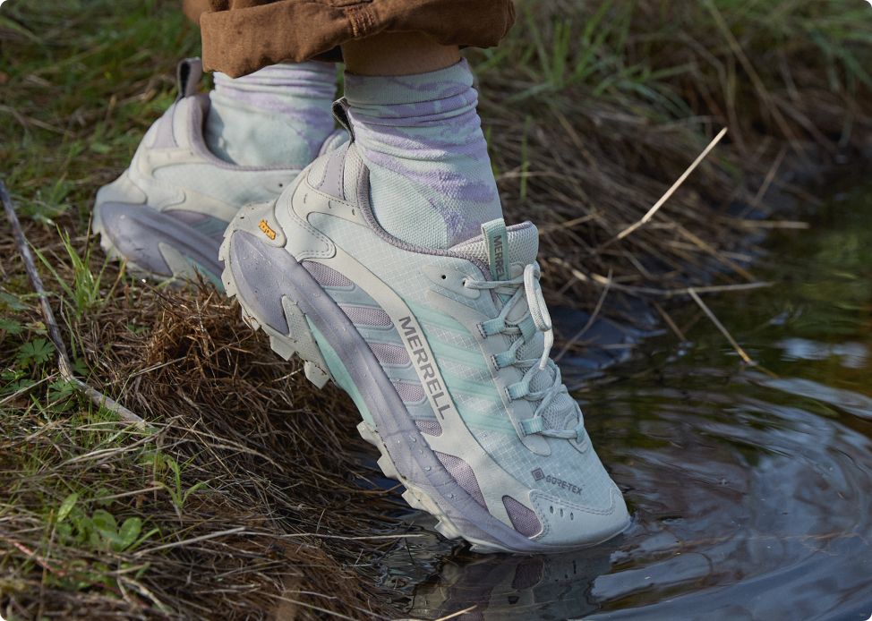 Person holding up wearing Merrell shoes