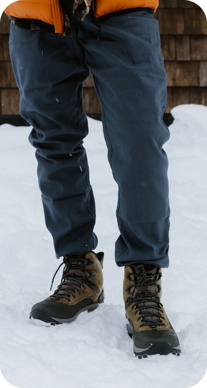Legs wearing jeans in boots standing in snow
