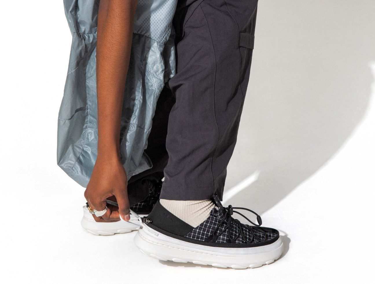 a person wearing black pants and white sneakers