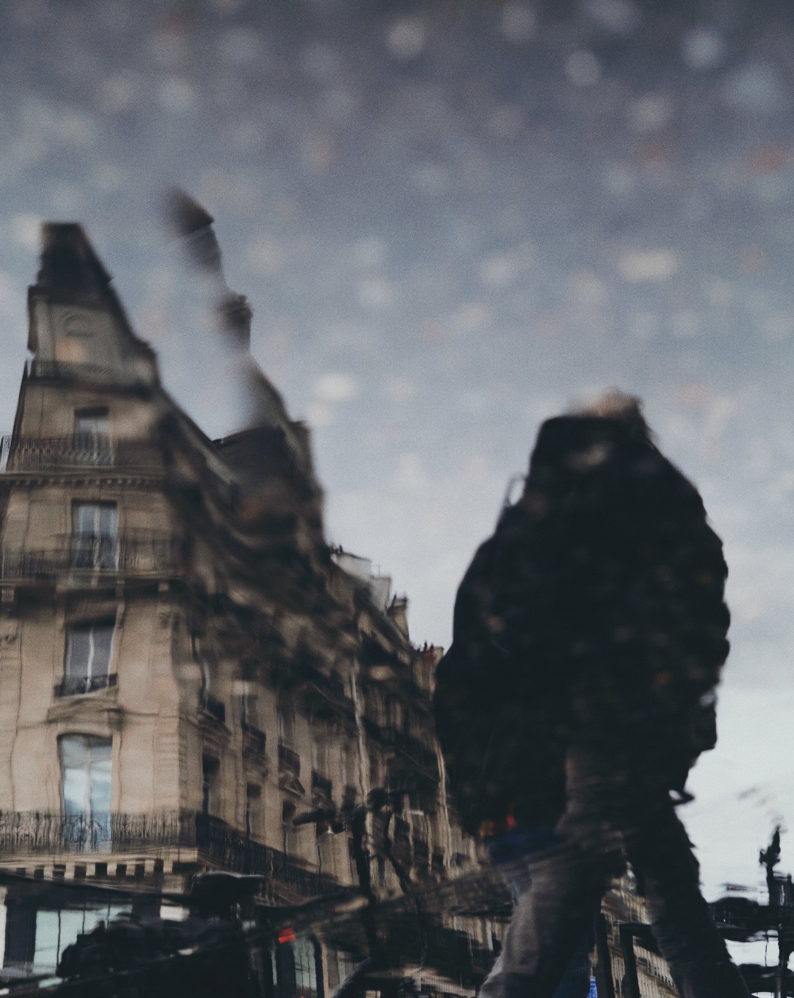 Reflection of a Paris street scene in a puddle