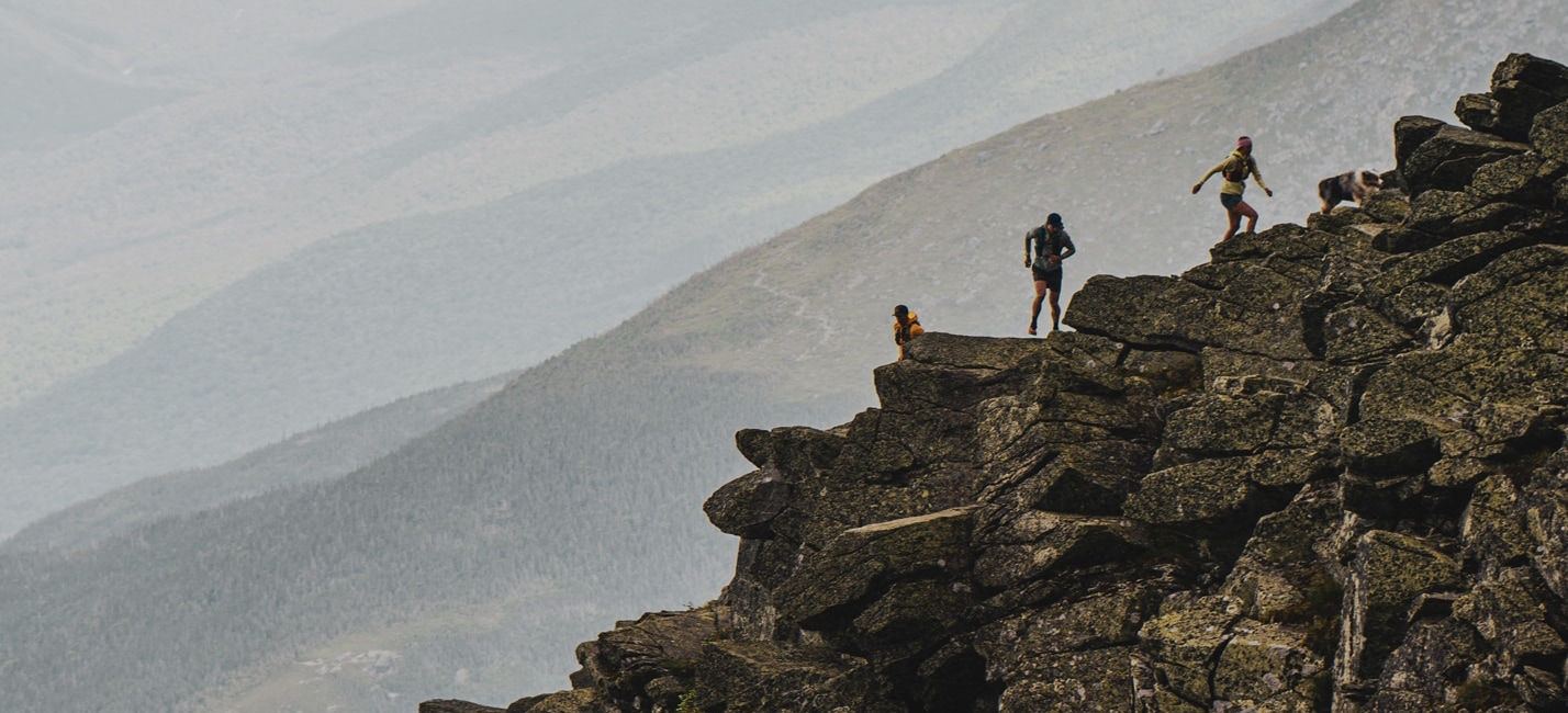 3 friends scrambling on a rocky mountain