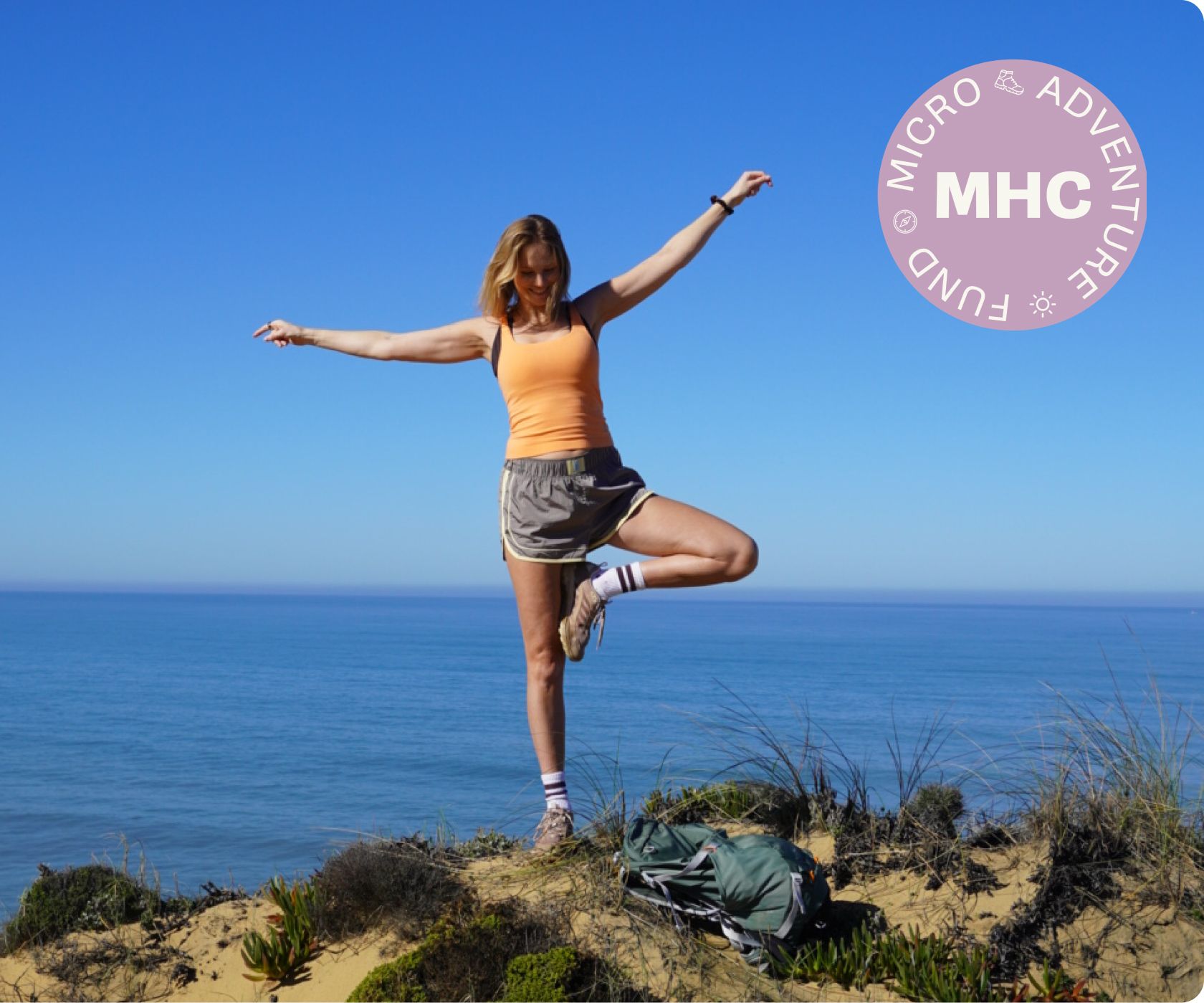 Woman standing on one leg on a cliff overlooking the ocean
