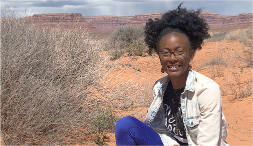 Latasha Dunston sitting in a desert setting.