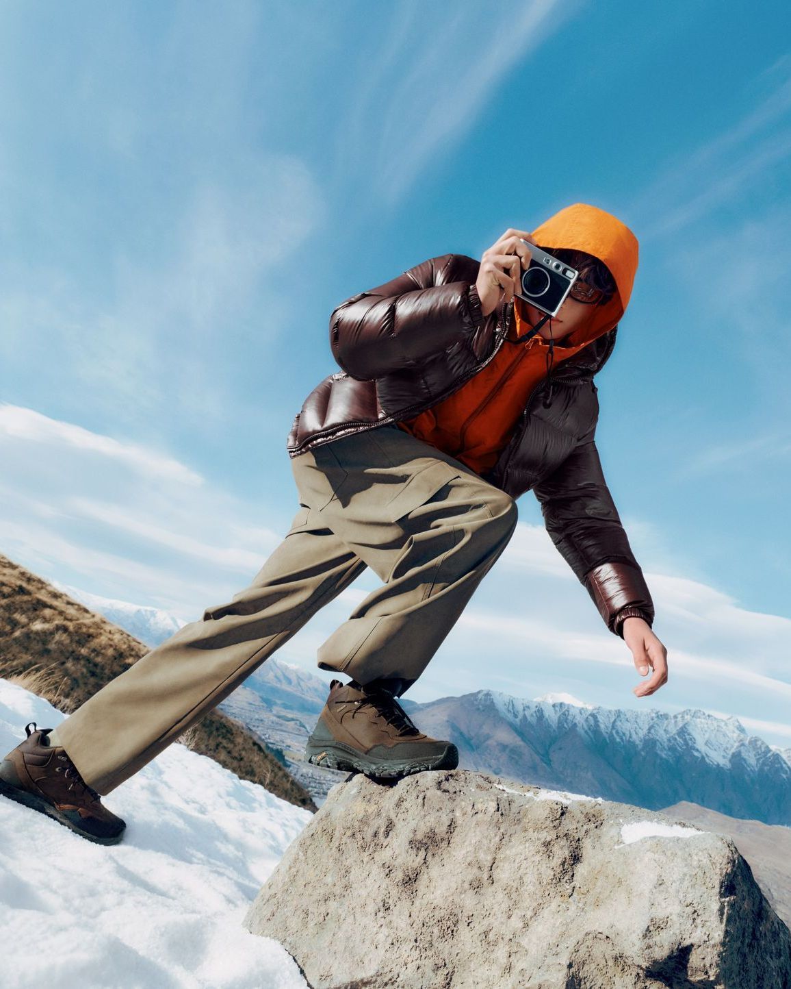 An outdoor adventurer wearing Merrell boots in a snowy mountain landscape.