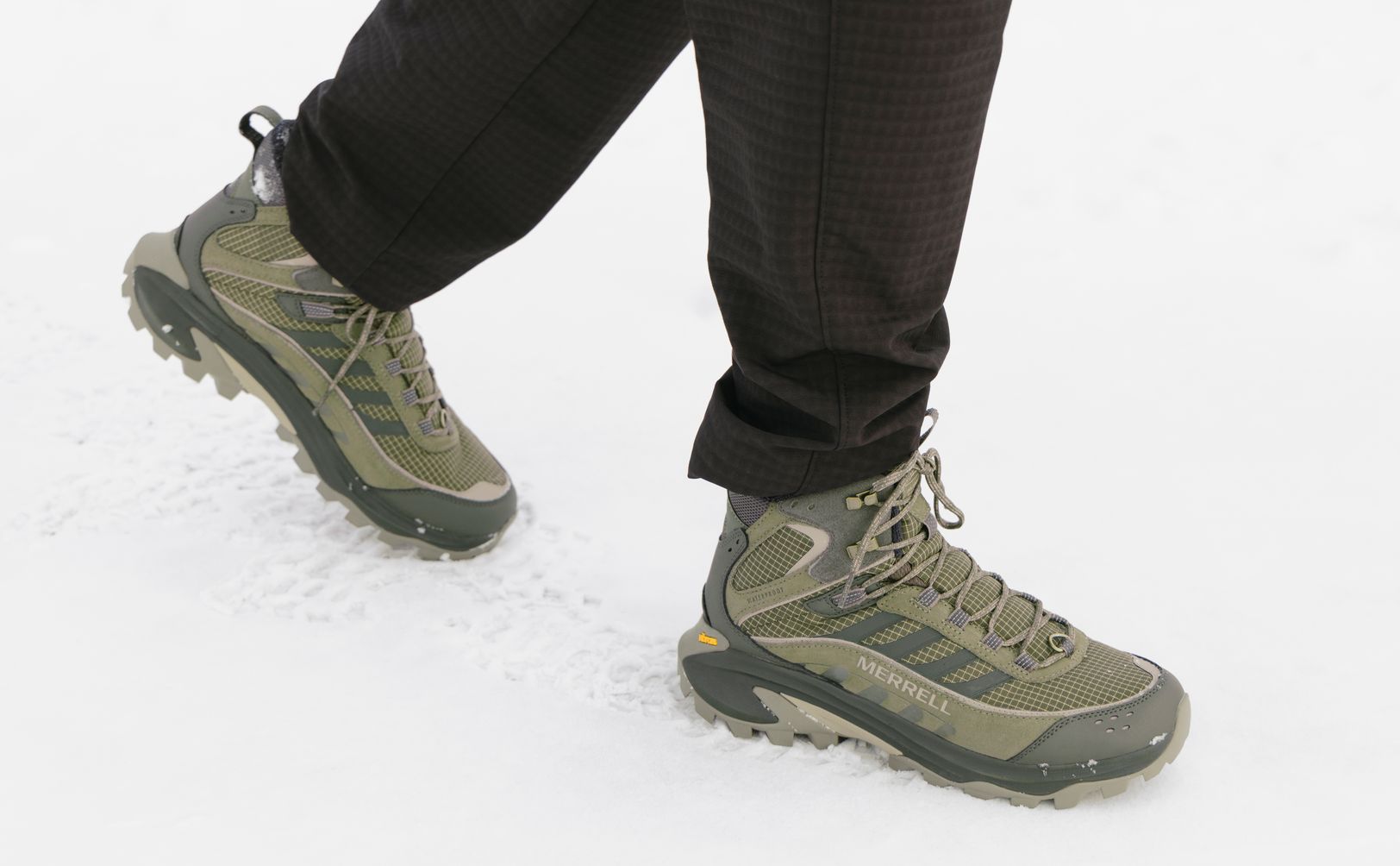 Green Merrell Moab Speed Thermo boots worn in the snow.