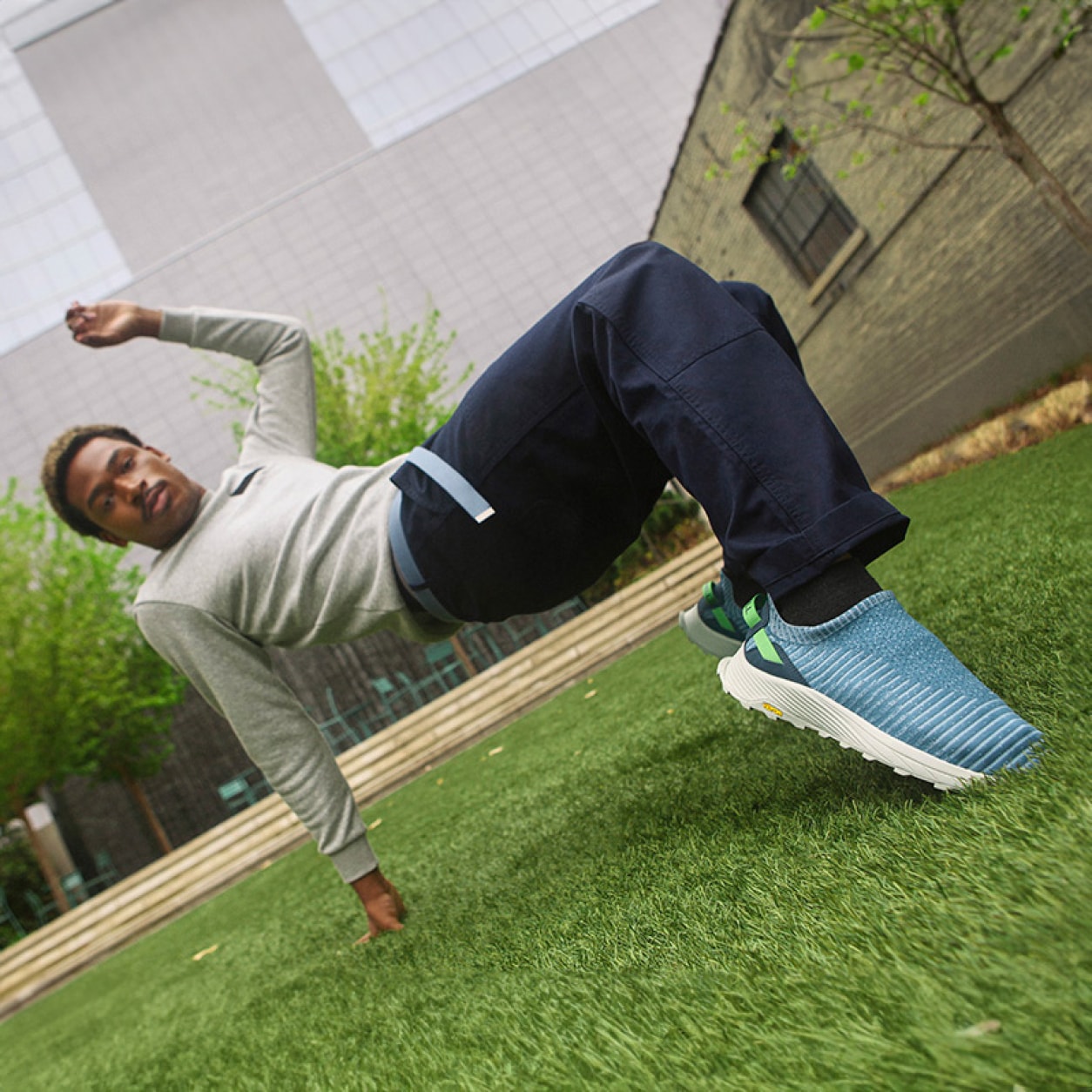 A person doing some cool dance moves in the grass, wearing embark mocs.