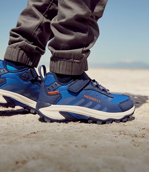 Child's feet in blue Merrell trail shoes.