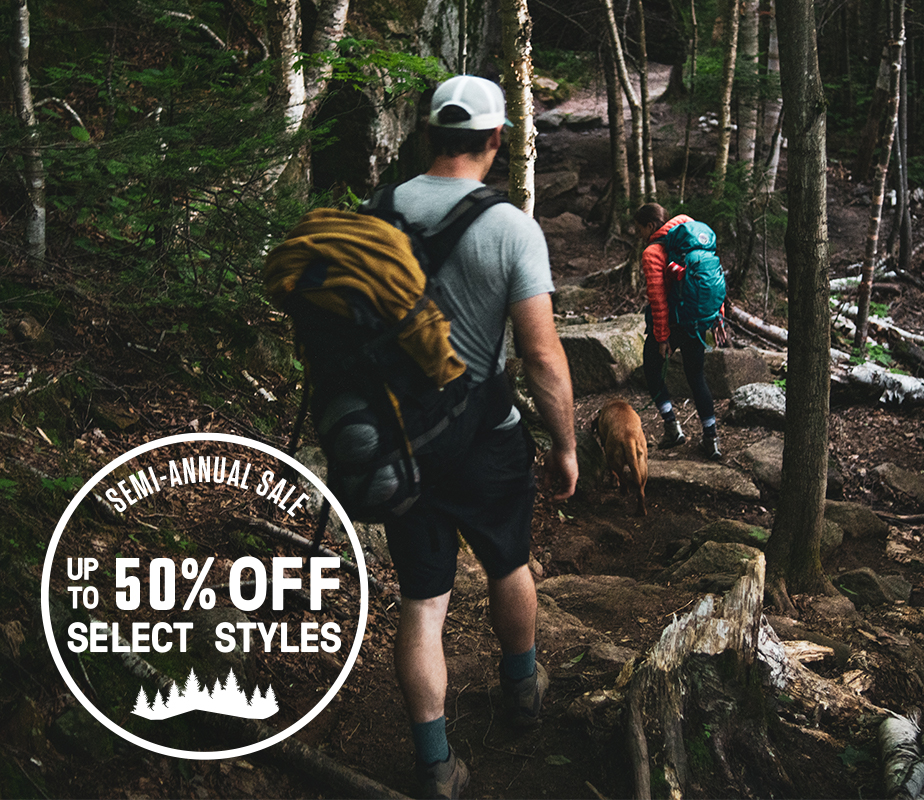 People hiking in a forest with Merrell gear.