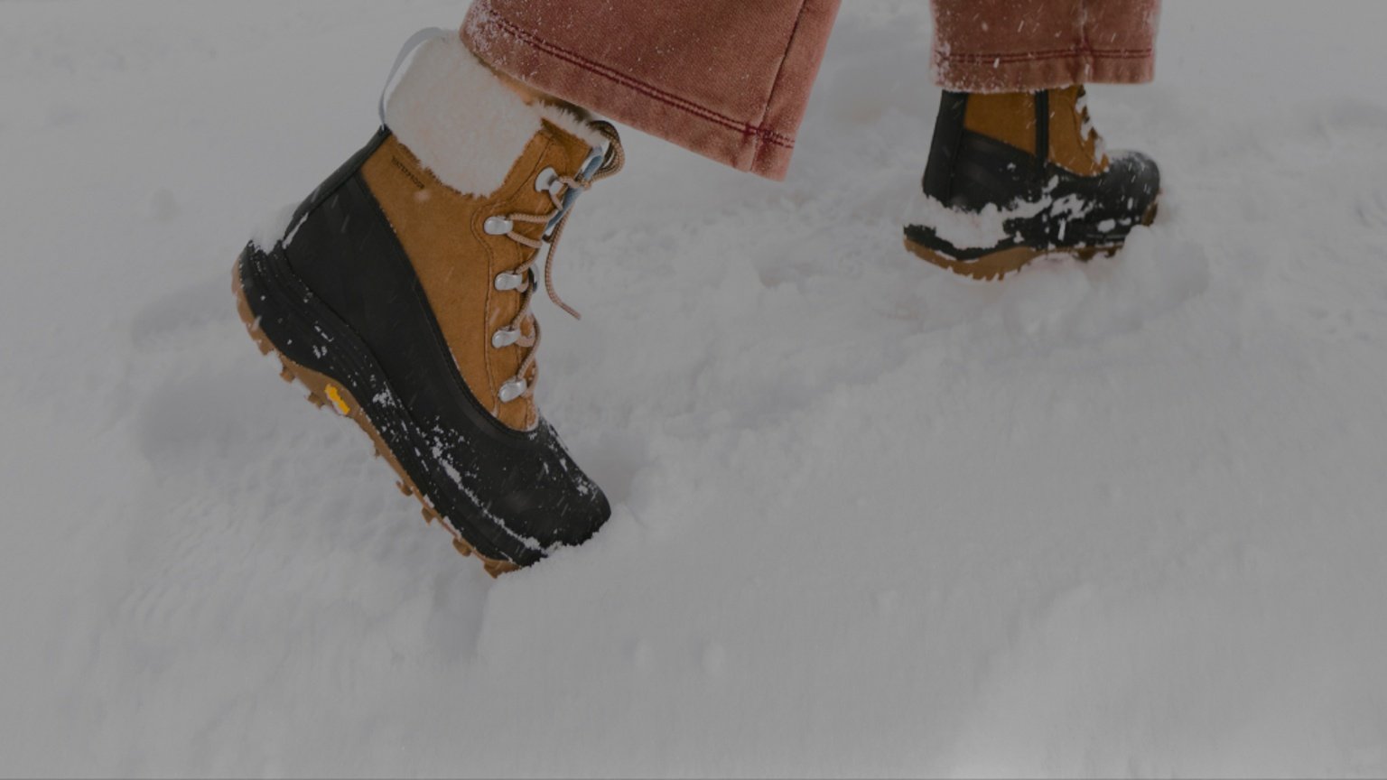 Merrell insulated winter boots walking through fresh snow