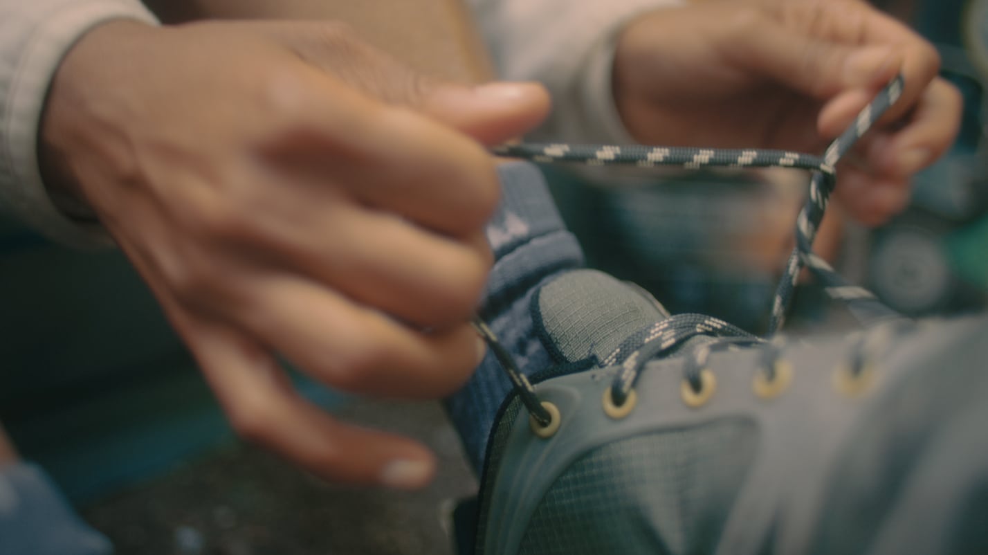 A close-up shot of someone tying the laces of thier Merrell Altalight shoe