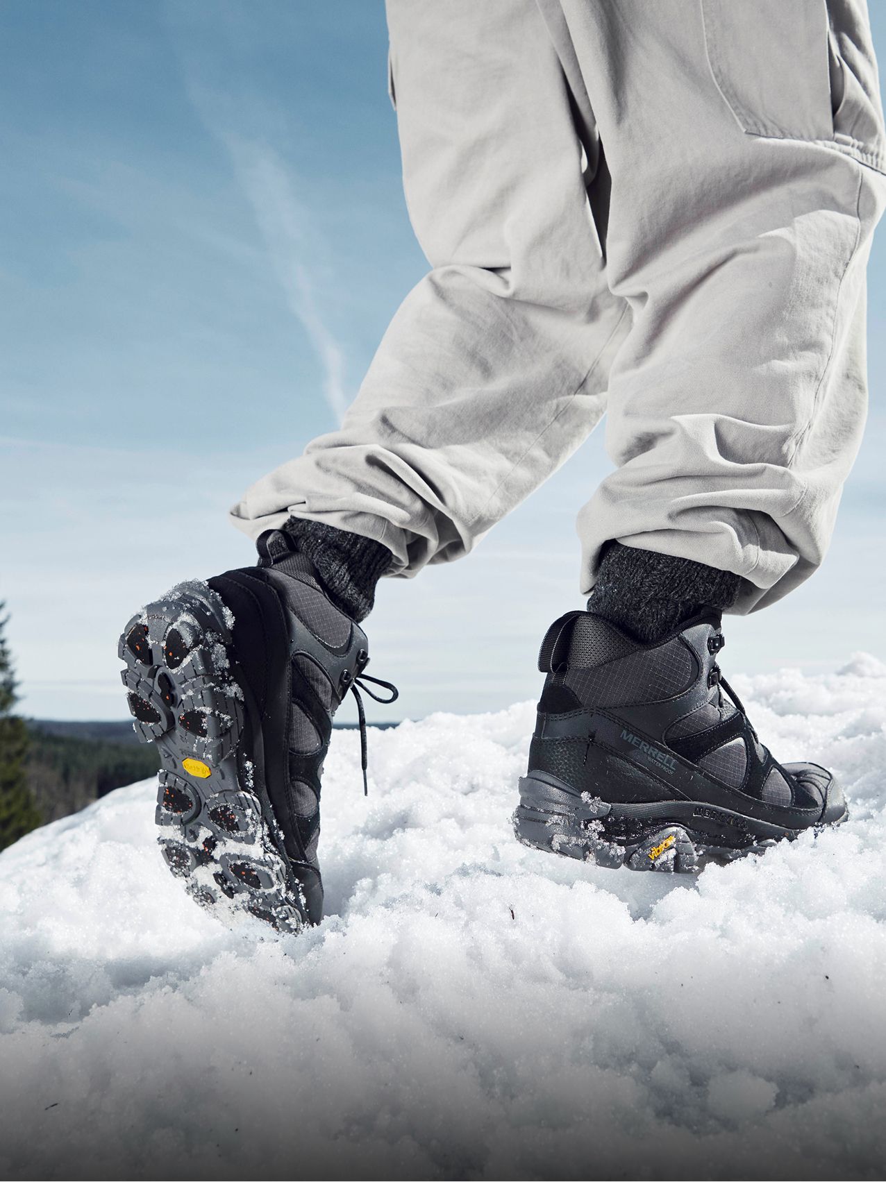 Person wearing Merrell boot on a snowy trail.
