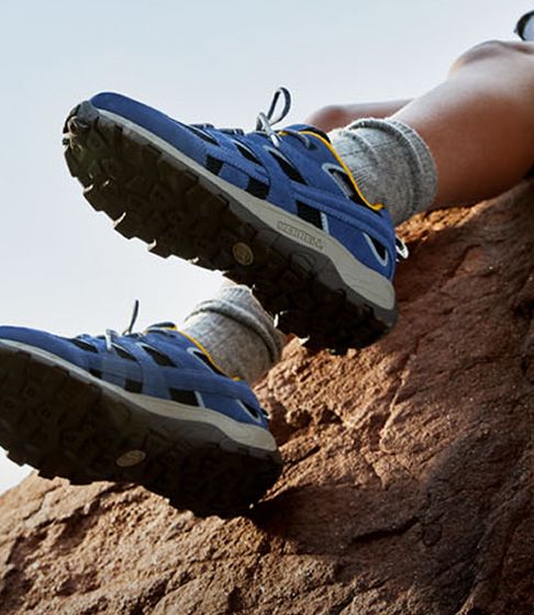 Kids wearing Merrell shoes outdoors.
