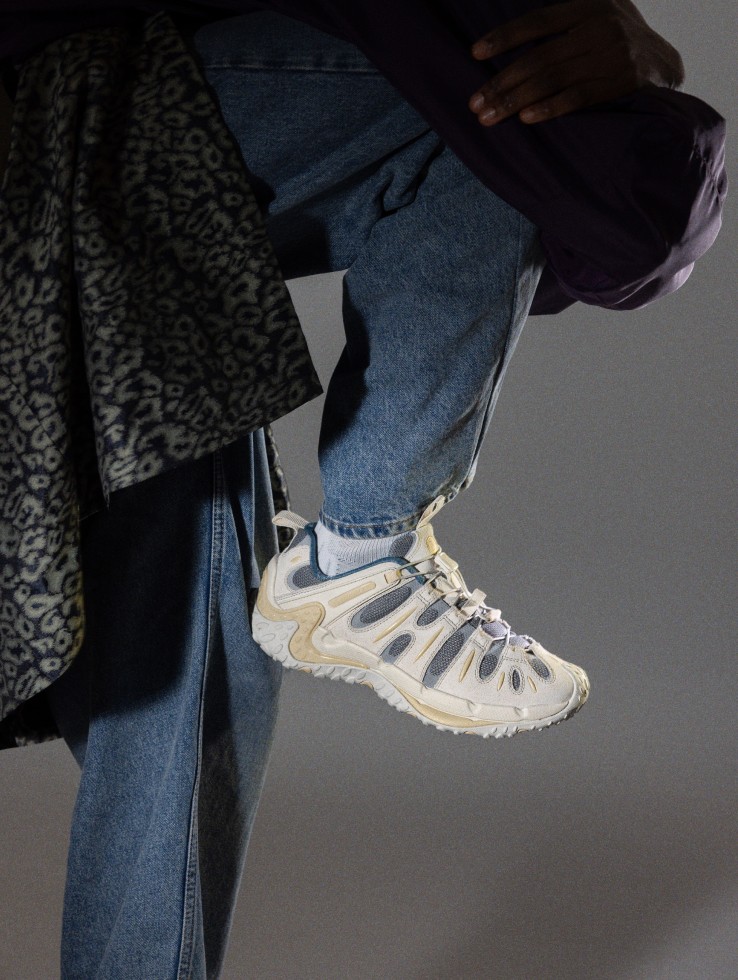 Person standing with white Cham Redux on and one foot off the ground.
